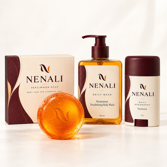 The NENALI Complete Ritual on a white ground: the soap carton, the round persimmon bar, the Daily Wash bottle and the Daily Deodorant stick