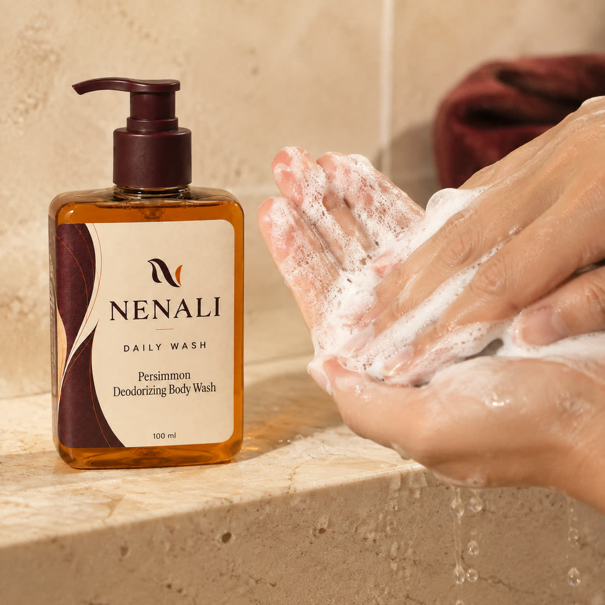 Hands lathering NENALI Daily Wash beside the bottle