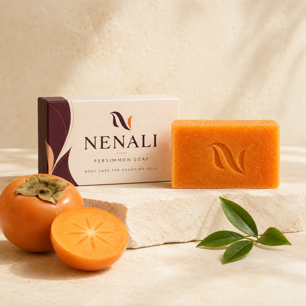 NENALI Reset Bar, carton and a halved persimmon on travertine